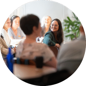 woman sitting in a chair smiling at her peers